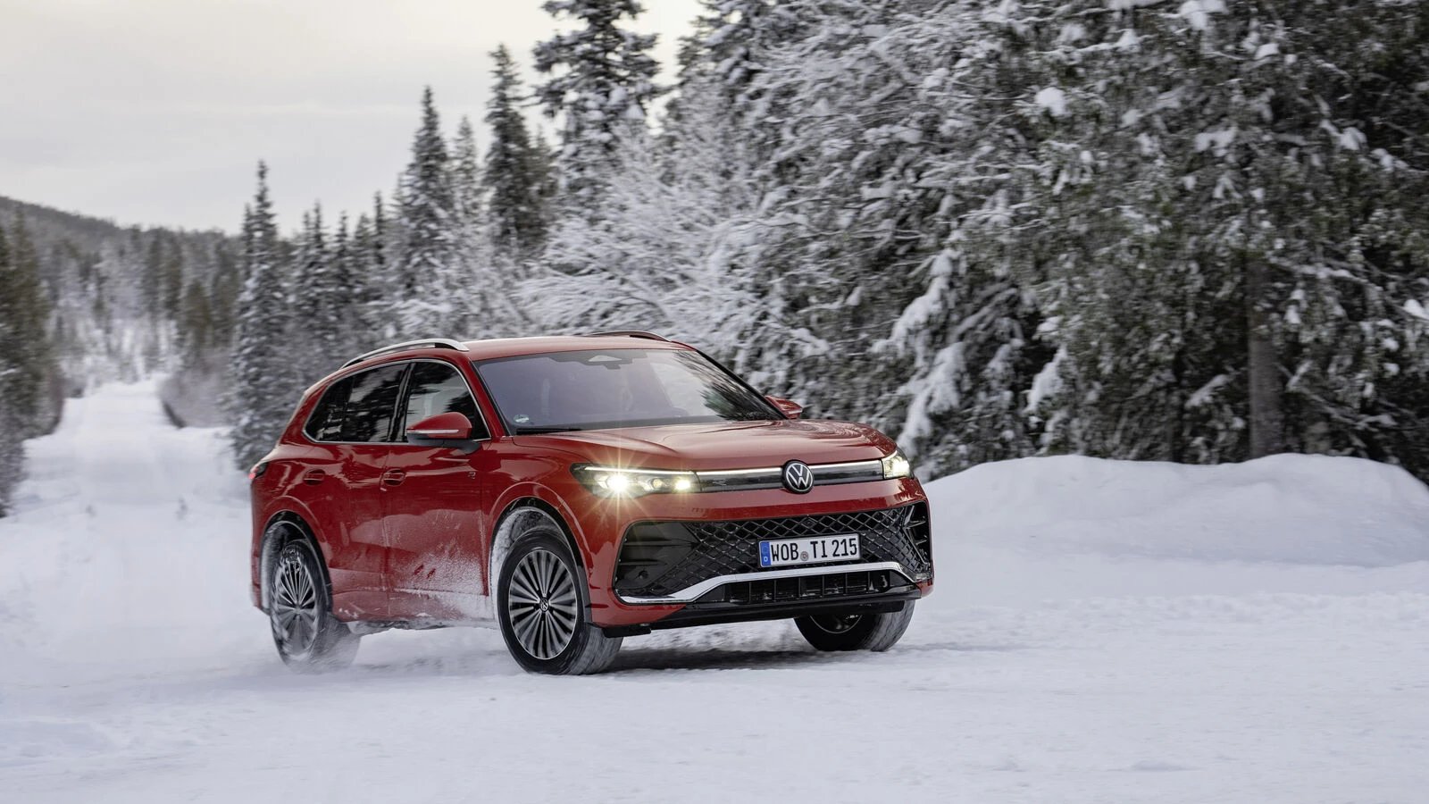 Rode Volkswagen Tiguan op een besneeuwde bosweg
